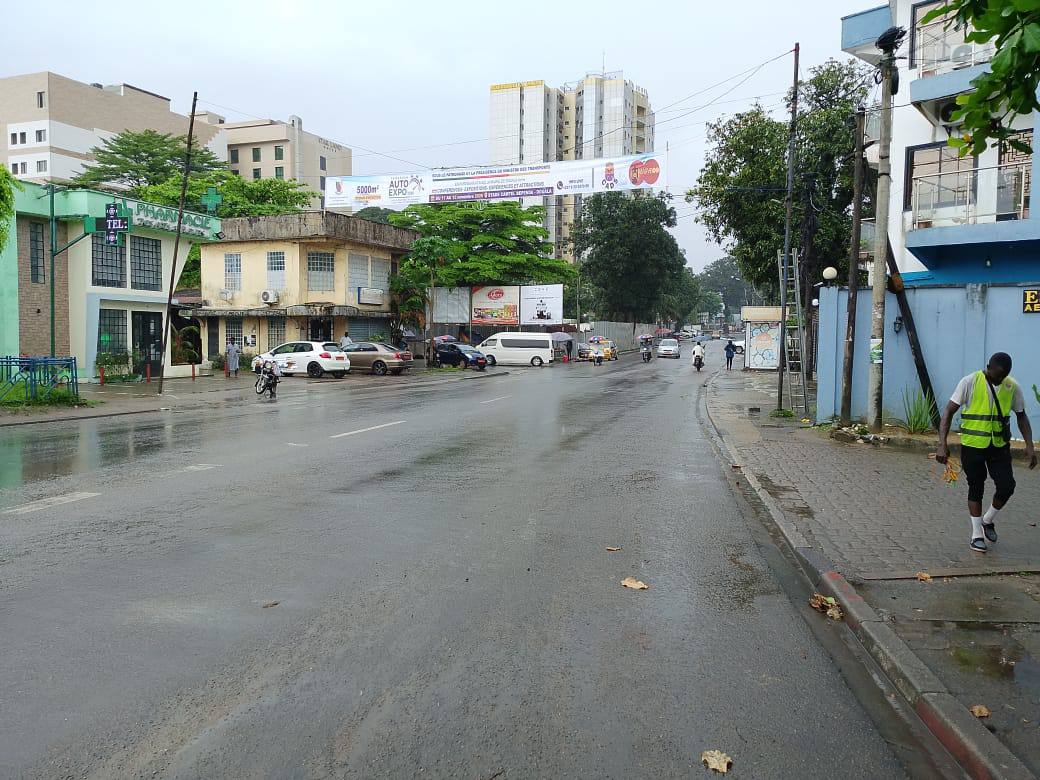 Banderole CAX sur une avenue de Douala après la pluie